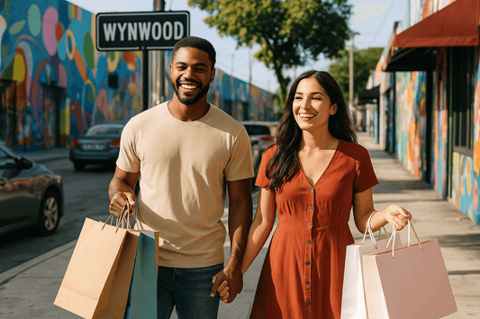 A young couple shopping in Wynwood, Miami, smiles as they walk hand-in-hand past colorful murals, capturing the vibrant energy often used in local advertising campaigns.