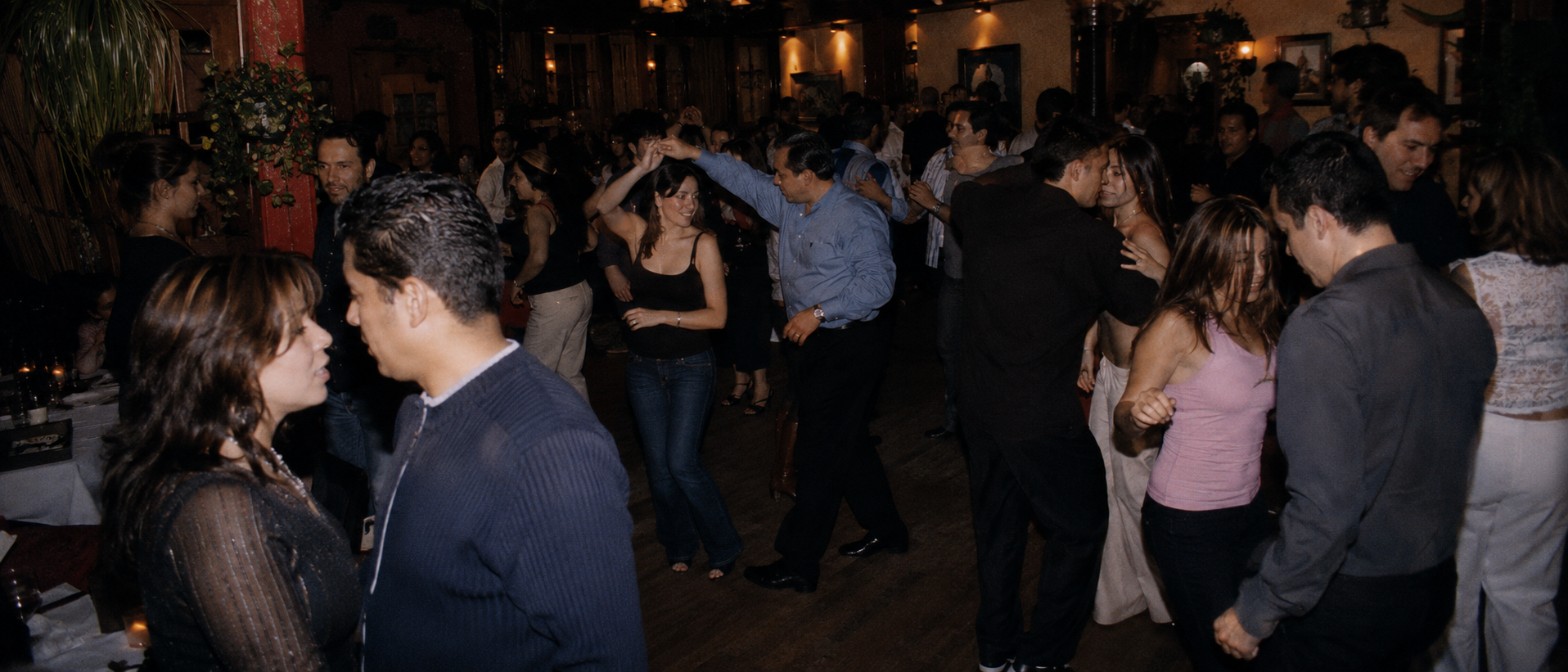 People dancing salsa at a crowded indoor nightlife event in Little Havana, Florida with warm lighting and a lively social atmosphere.